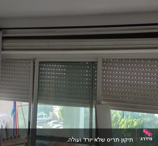 תריסים סגורים למחצה על חלון זכוכית גדול